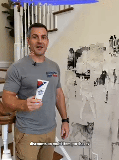 A man demonstrates areas of damaged wall