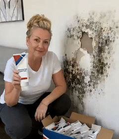 Applying wall repair paste beside a window